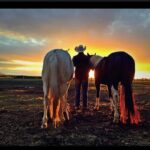 david cowley with 2 horses facing sunset